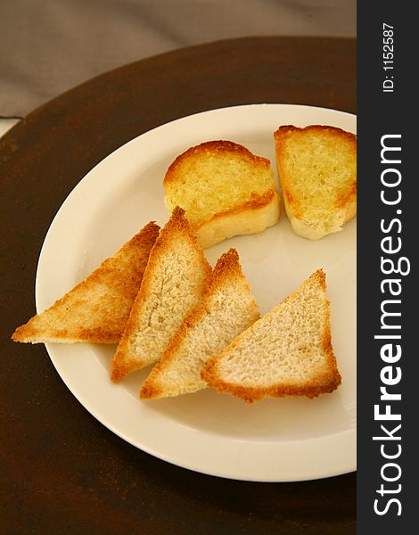 Pieces of white toasted bread on a white plate isolated