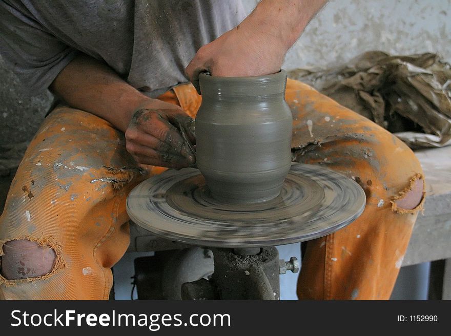 Potter at his workshop, during making a vase. Potter at his workshop, during making a vase.