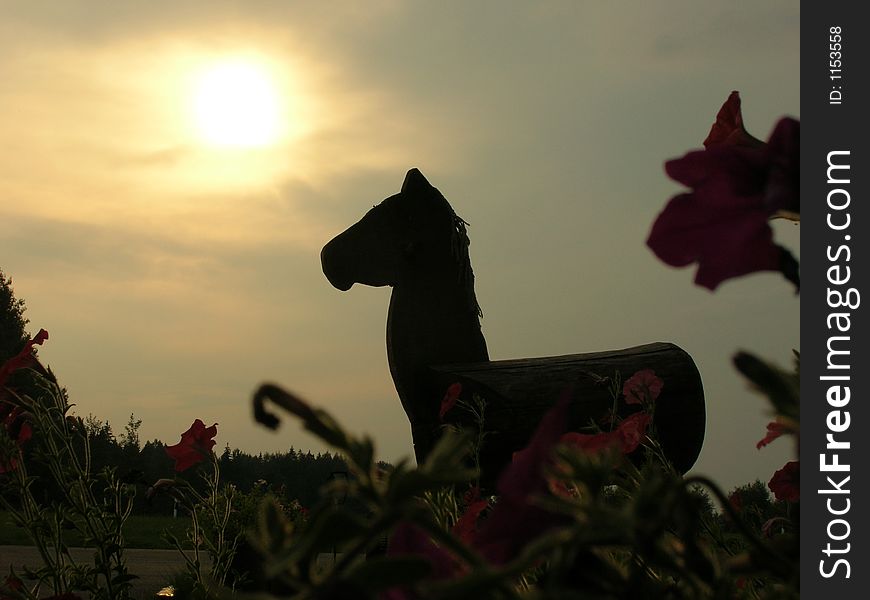 A photo of a wooden horse in the evening. A photo of a wooden horse in the evening