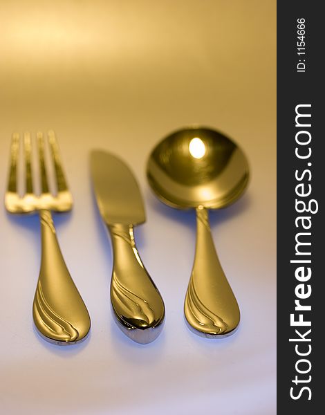 Knife, fork, spoon with focus on grips in colored environment. Knife, fork, spoon with focus on grips in colored environment