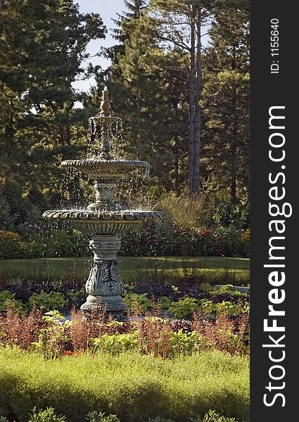 Fountain in formal garden with tree background. Fountain in formal garden with tree background