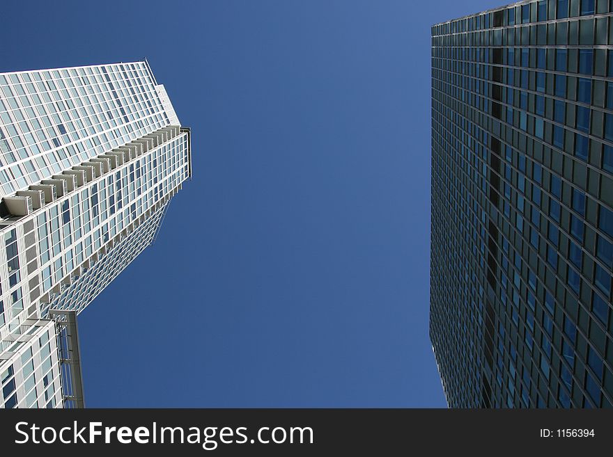 Double corporate downtown office buildings looking up toward the blue sky. Excellent for corporate brochure. Double corporate downtown office buildings looking up toward the blue sky. Excellent for corporate brochure.