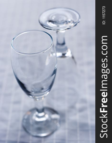 Two empty wine glasses on a white surface