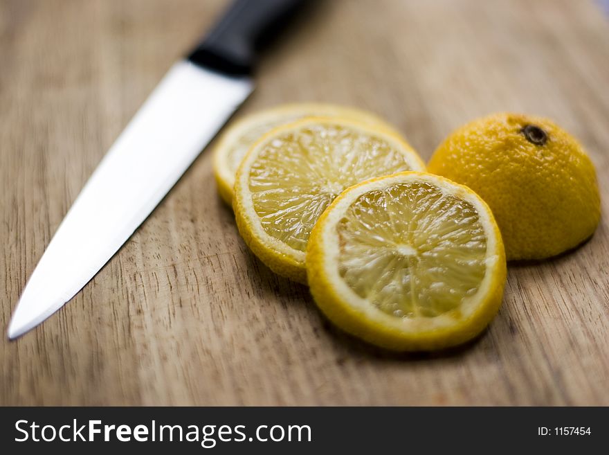 Sliced lemon on a chopping board with knife. Sliced lemon on a chopping board with knife