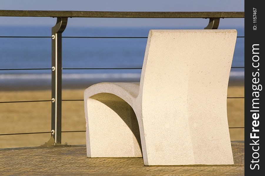 A chair with the sea on the background. A chair with the sea on the background