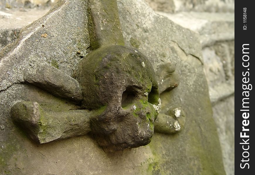 An old gravestone with a skull and crossbones.