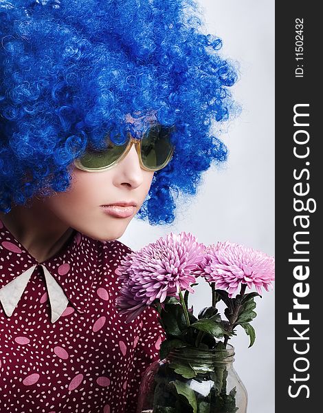 Young beauty clown in dark blue wig with flowers. Young beauty clown in dark blue wig with flowers