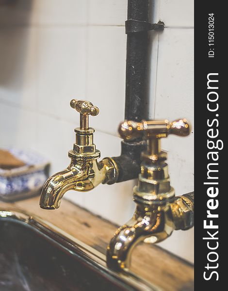 Shallow Focus Photography of Gold Faucets