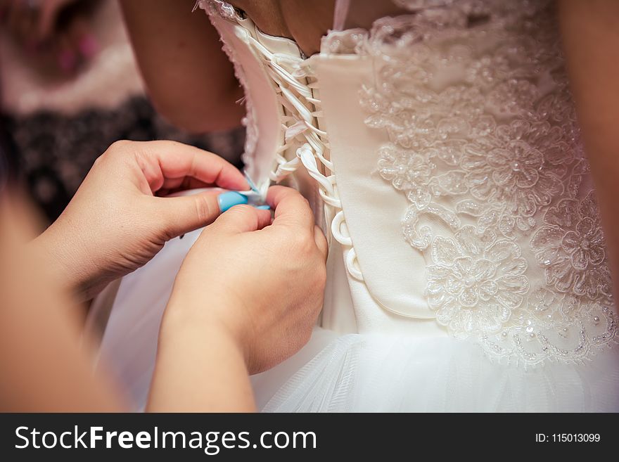 Photo of Woman Fixing the Wedding Gown