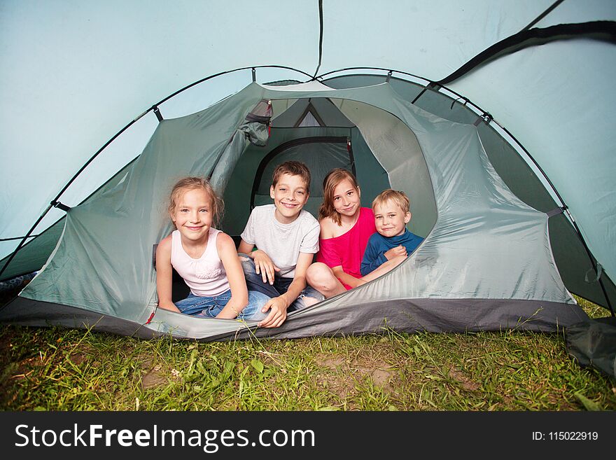 Children in a tent. Camping. Happy kids at summer vacations. Children in a tent. Camping. Happy kids at summer vacations