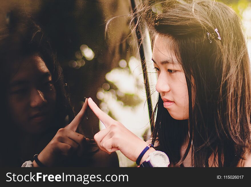 Sweet Asian Girl Looking Into Car`s Mirror And Writing Something