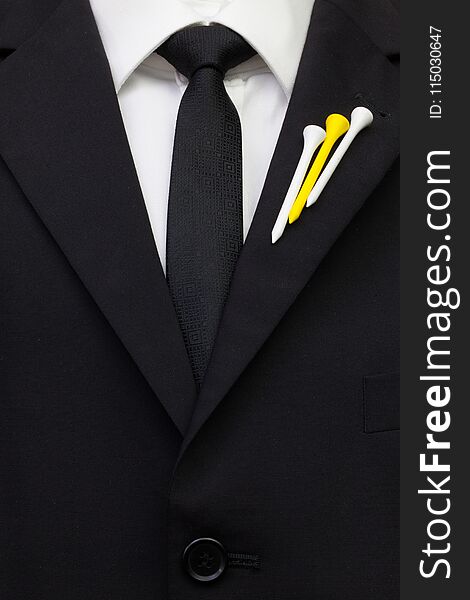 The detail of wedding suit with golf design. Blue golf tees on the flap of black jacket.