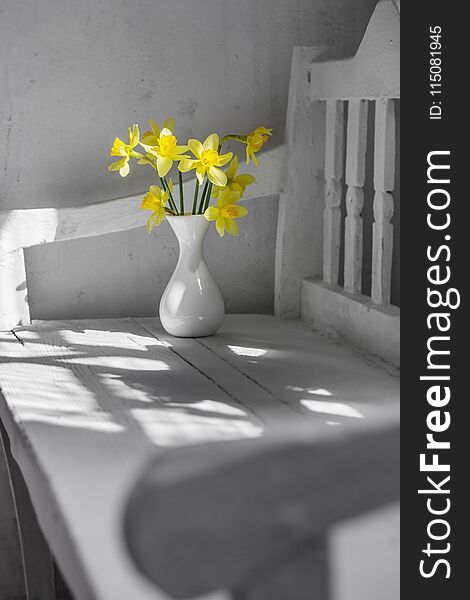 yellow spring flowers on white wooden bench. yellow spring flowers on white wooden bench