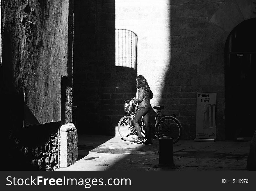 Grayscale Photo of Woman with Her Bicycle
