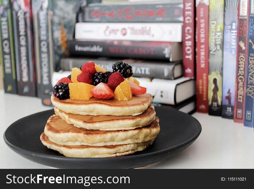 Pancake on Black Plate Near Books