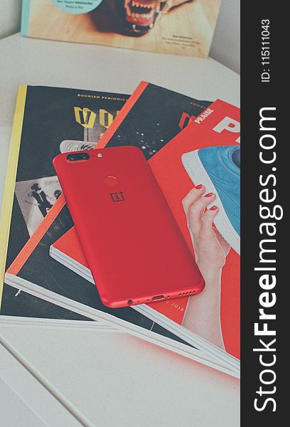 Red Oneplus Smartphone on Books