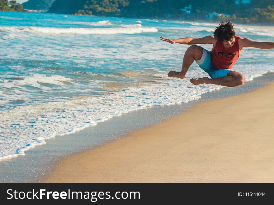 Photography of a Man Jumping on Beach
