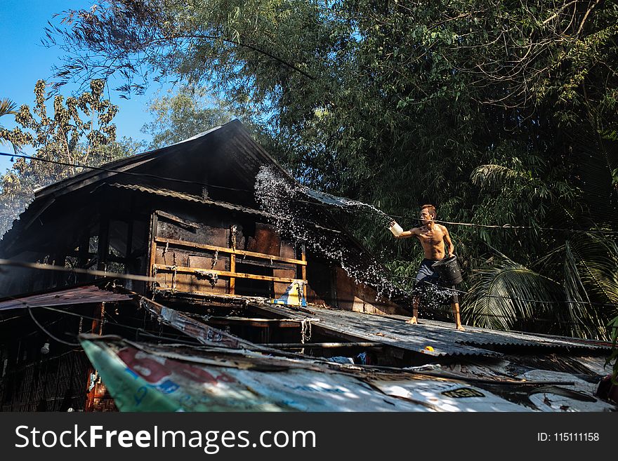 Man Throwing Water on Roof