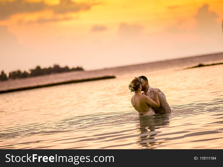 Woman And Man Kissing In Body Of Water