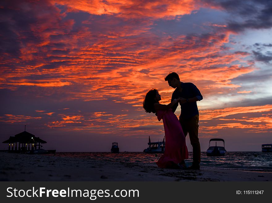 Man and Woman on Beach during Sunset
