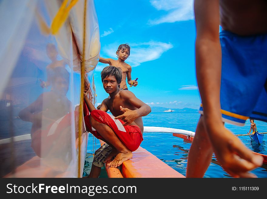 Teenage Boys Sitting on Edge of Boat