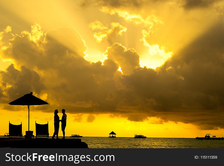 Silhouette Photo of Man and Woman Beside Body of Water during Sunset