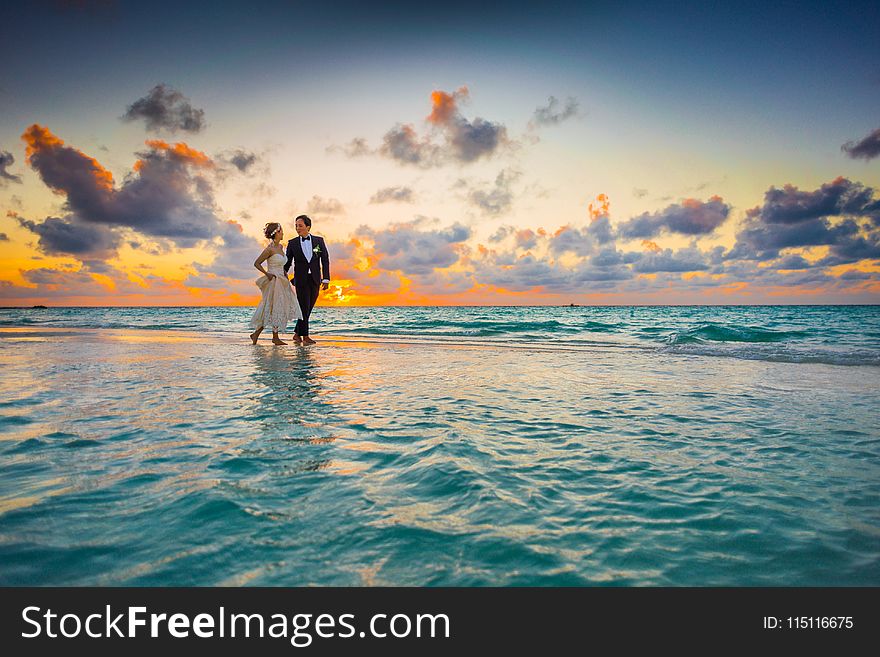 Man And Woman Walking Of Body Of Water