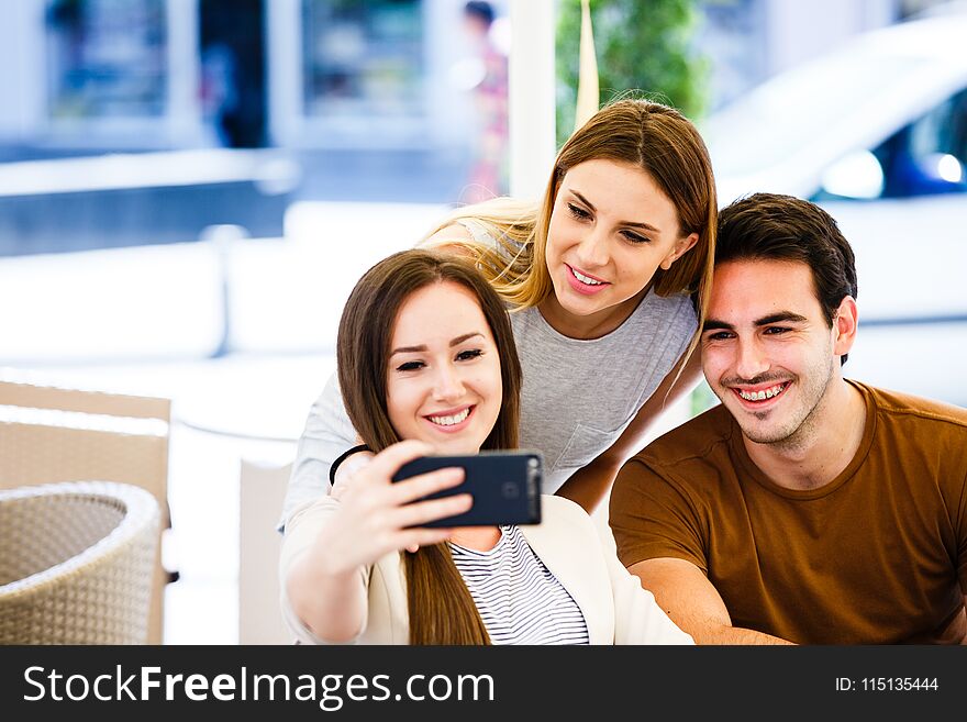 Young friends taking selfie while sitting at cafe