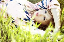 Young Woman Enjoying The Lying On Her Back On The Green Grass In The Garden. Royalty Free Stock Photography