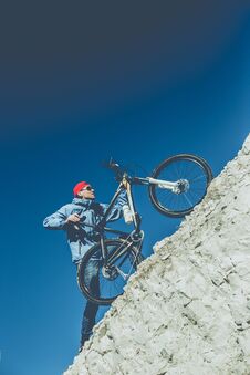 Young Guy With A Bicycle On A Chalky Mountain Stock Photography
