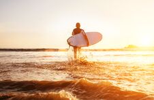 Surfer Runs With Surfboard Towards Ocean Waves Ta Sunset Time Stock Image