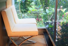 Relaxing Moment In The Coffee Cafe, Soft Cream Leather Sofas With The Black Glass Table Next To Large Window With Green Decorative Stock Images Relaxing Moment In The Coffee Cafe, Soft Cream Leather Sofas With The Black Glass Table Next To Large Window With Green Decorative Stock Images