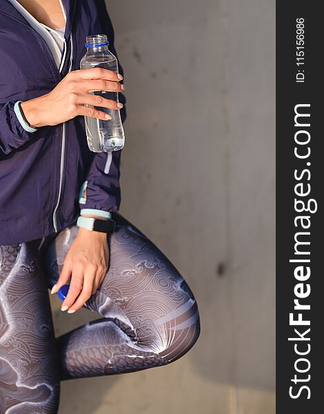 Urban fitness workout concept. Close up of woman in sportswear drinking water during training rest. Urban fitness workout concept. Close up of woman in sportswear drinking water during training rest.