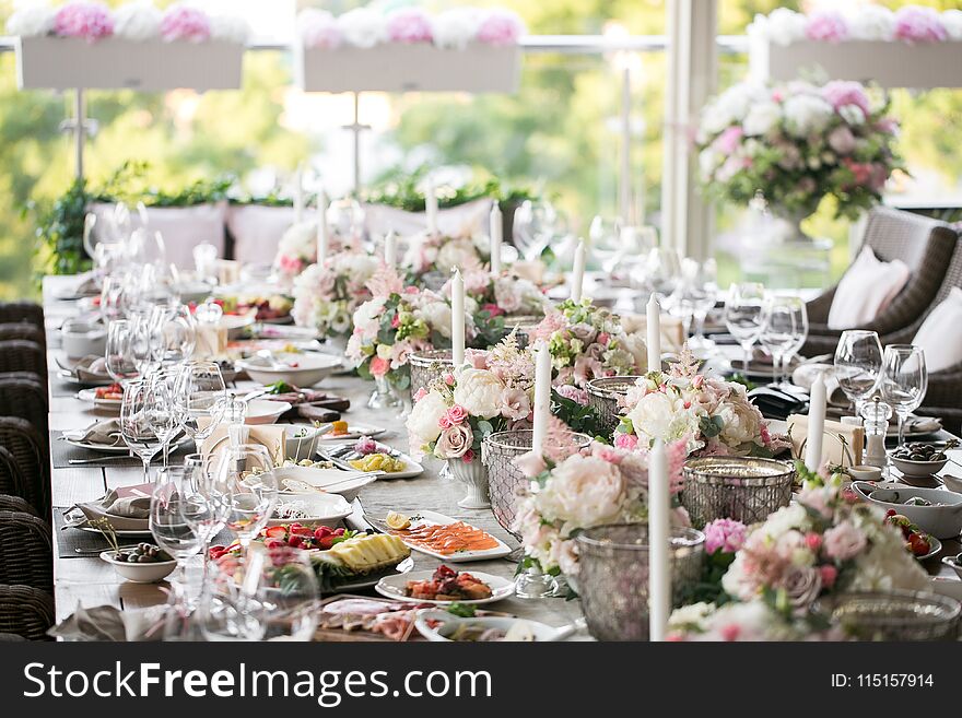 Garland of flowers and greenery for table decoration. Luxury wedding reception in restaurant. Stylish decor and adorning