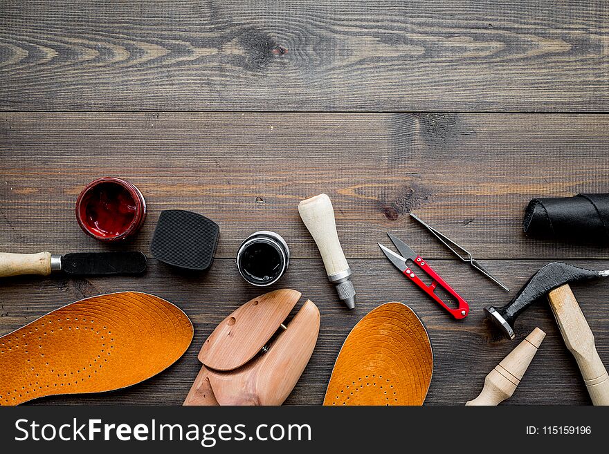 Tools For Shoe Repair. Hummer, Awl, Knife, Sciccors, Wooden Shoe, Insole, Paint And Leather. Dark Wooden Background Top