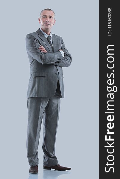 Mature business man arms folded on gray.