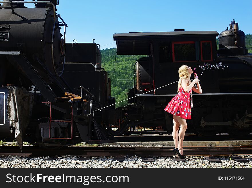 Young woman in red dress waiting at train station. Young woman in red dress waiting at train station