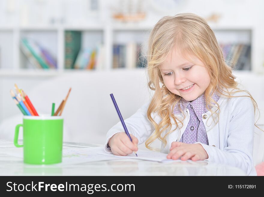 Portrait of cute little girl drawing with pencils