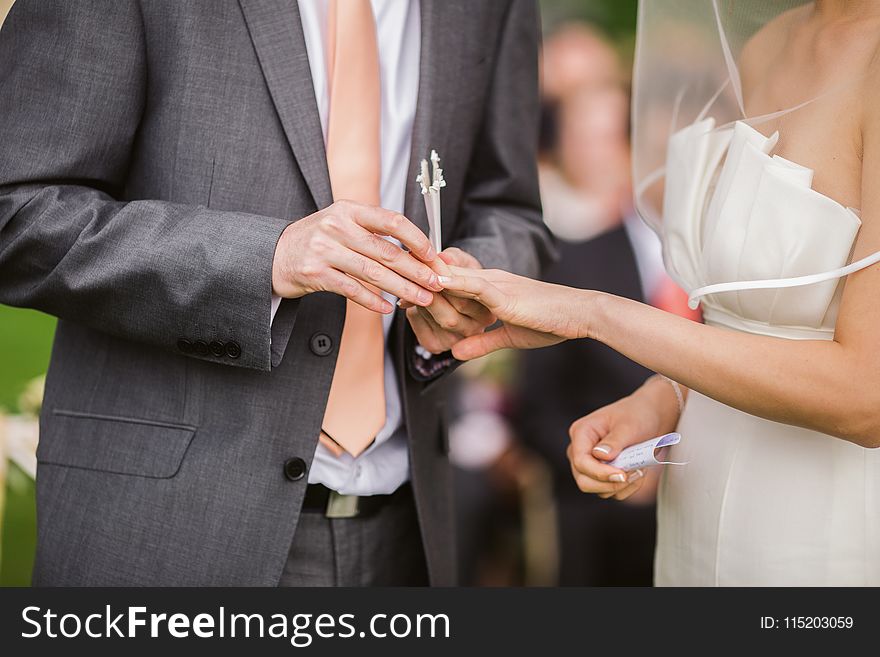 Photo of Groom Putting Wedding Ring on His Bride