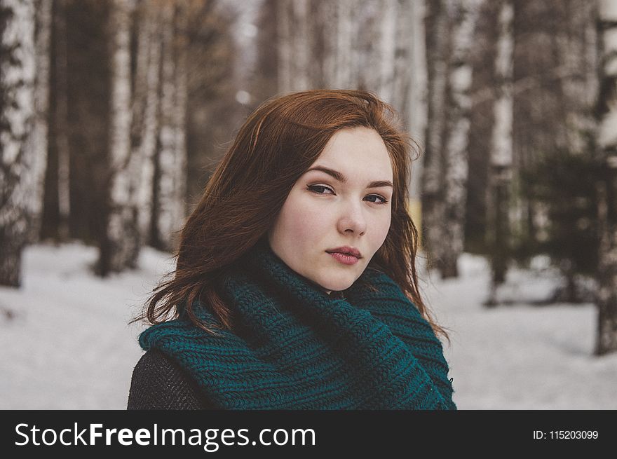 Selective Focus Photography Of Woman Wearing Blue Scarf While Standing On Snow Covered Forest