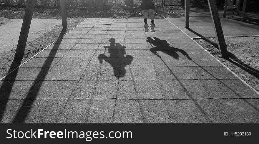 Grayscale Photo of Two Children Using Swing