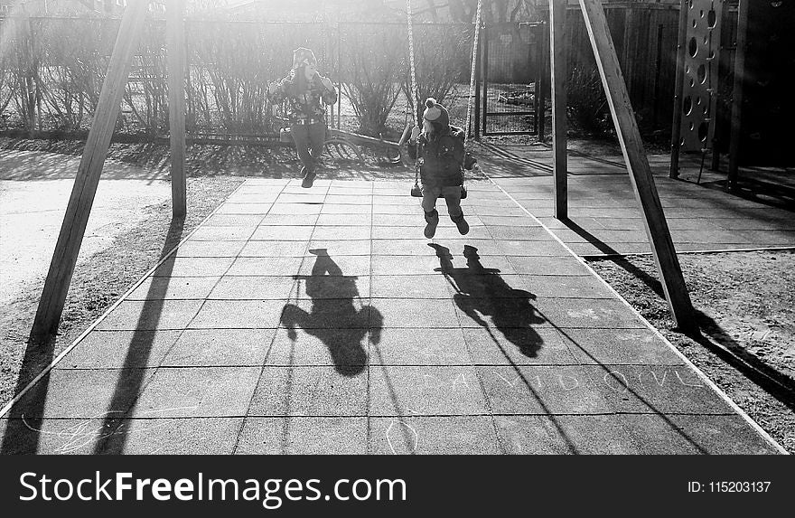 Monochrome Photography Of Children On Swing