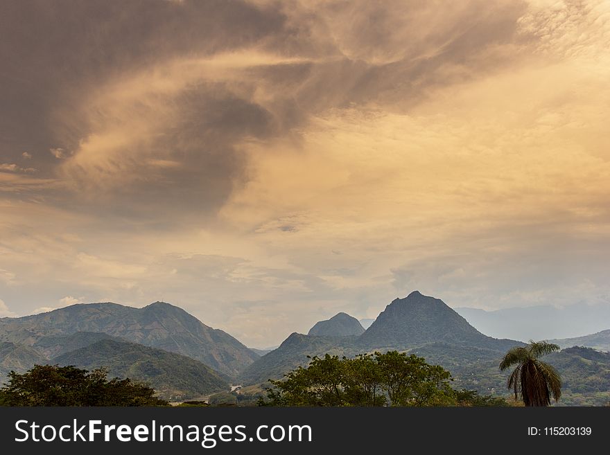 Scenic View Of Mountain Under Cloudy Sky