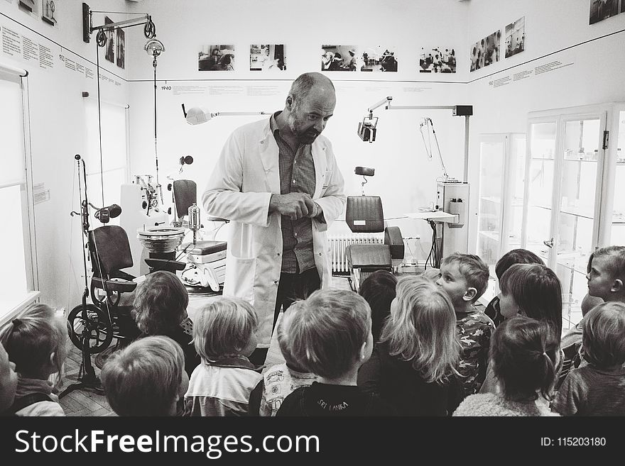 Grayscale Photo of Man Lecturing Children