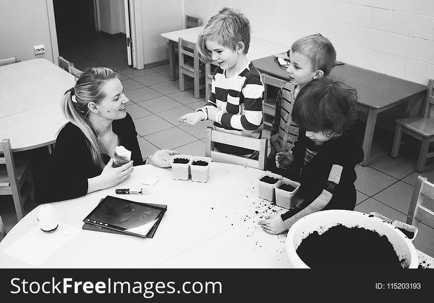 Mother and Three Child Near Table With Mud