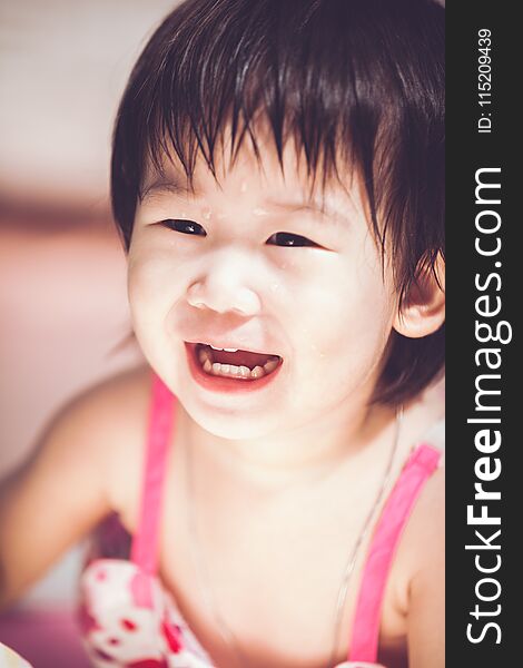 Asian girl smiling with perfect smile with drop on her face.