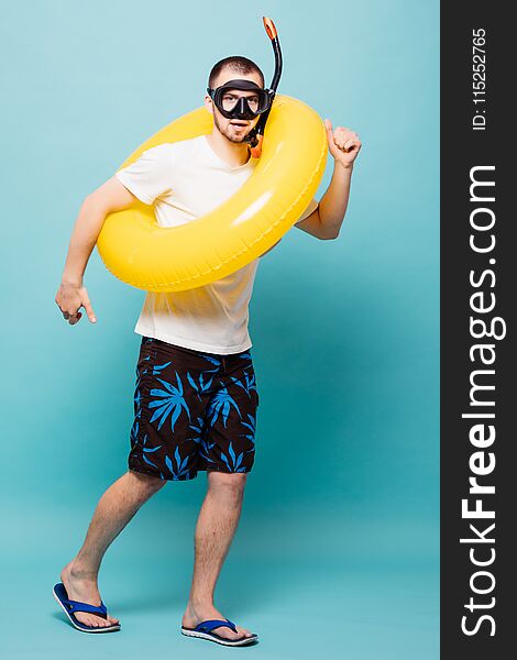 Full Lenght Of Young Handsome Man With Inflatable Yellow Ring And Snorkel Mask Runing Away Isolated On Green Background