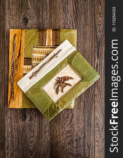 Handmade notebooks decorated with natural plants on wooden background