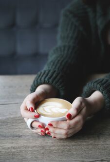 Female Hand Hold Coffee Cup With Heart Shape On Wooden Table Stock Photography