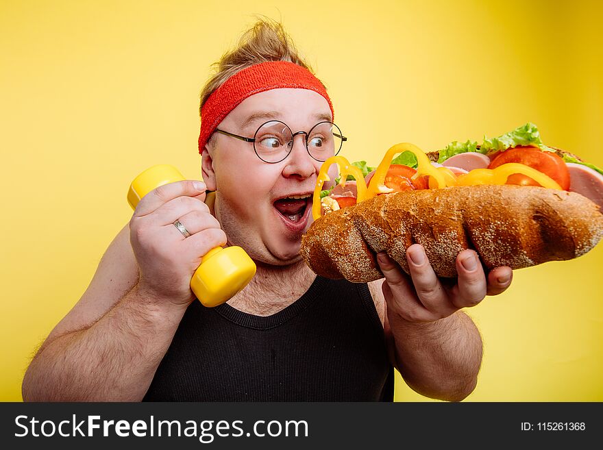 Fat funny man eating unhealthy big burger. Fat funny man eating unhealthy big burger